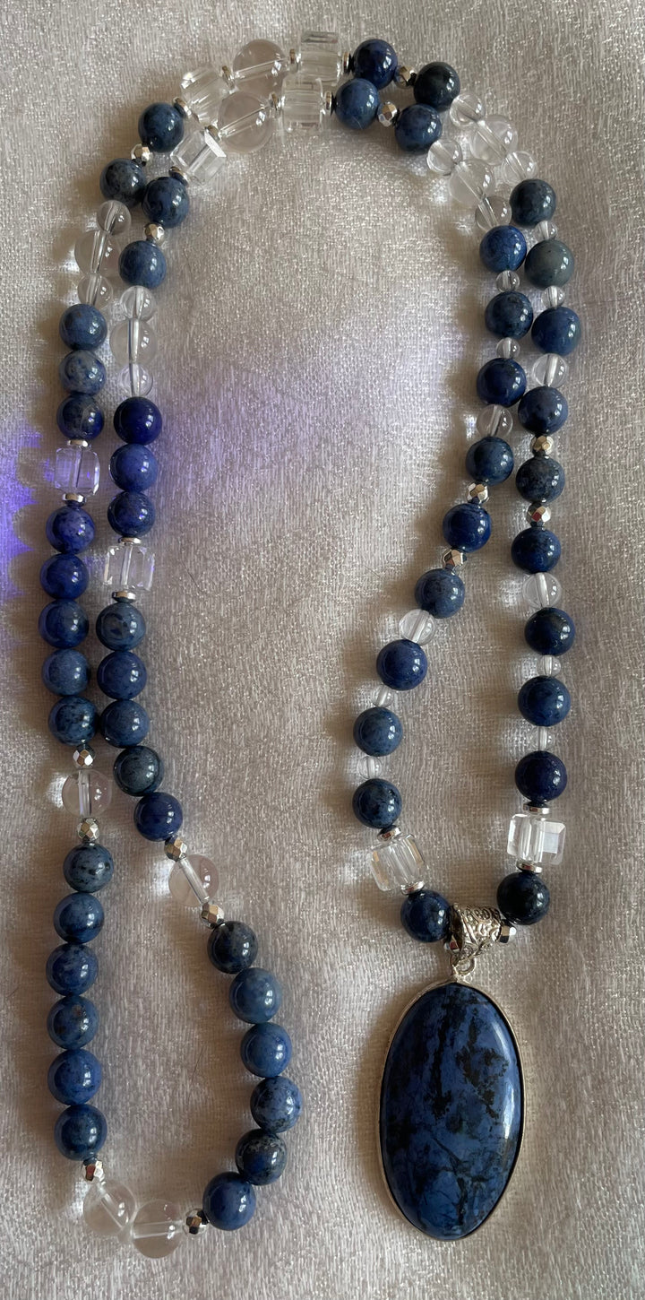 A Dumotierite and Clear Quartz Mala with a Dumotierite pendant, composed of round beads and featuring a central, oval-shaped stone pendant.