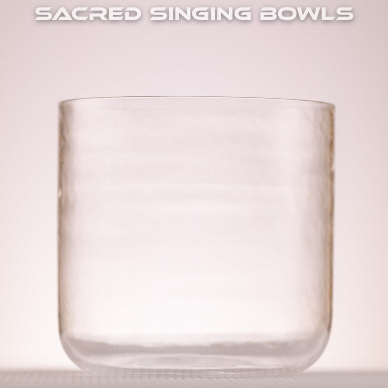 A clear quartz crystal singing bowl with a smooth surface, displayed against a neutral background with the text 'SACRED SINGING BOWLS' above.