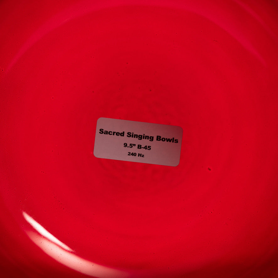 Red singing bowl with a label indicating 'Sacred Singing Bowls' and specifications.