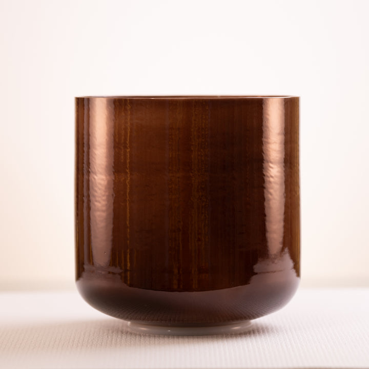 A dark brown, pearlescent singing bowl with a smooth surface, displayed against a neutral background.
