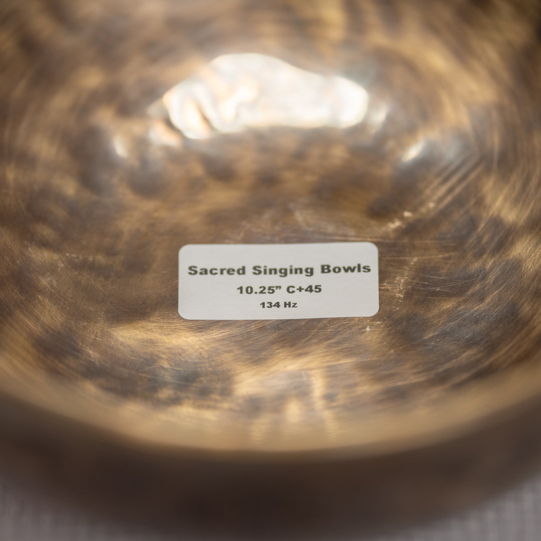 Close-up of a sacred singing bowl with a label indicating its specifications.