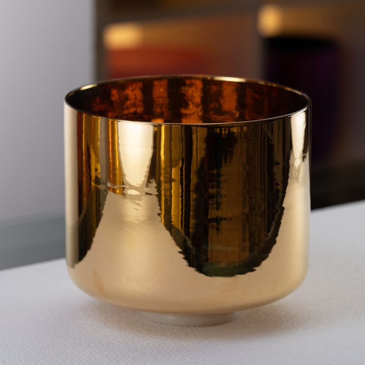 A 10 inch E-8 24k gold crystal singing bowl with a perfect pitch. The bowl has a reflective gold finish and is displayed against a neutral background.
