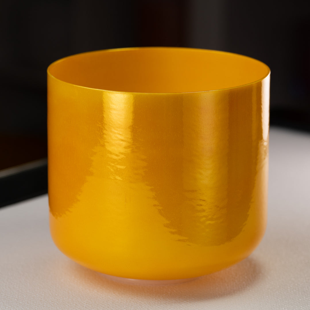 A 10 inch pearlescent yellow singing bowl, crafted from quartz crystal, with a bright and shiny surface.