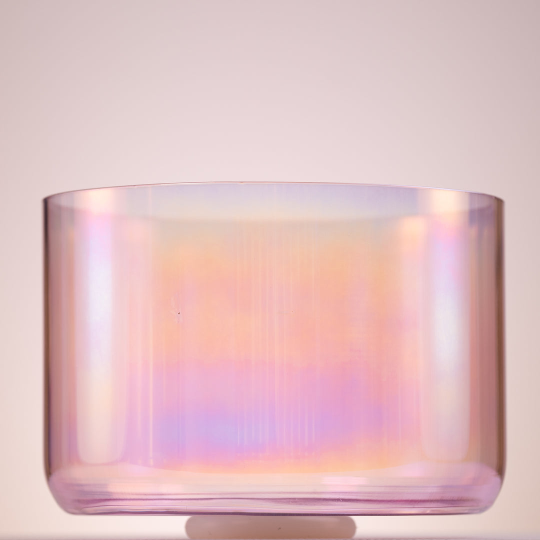 A light pink, round quartz crystal singing bowl, used for meditation and sound therapy.