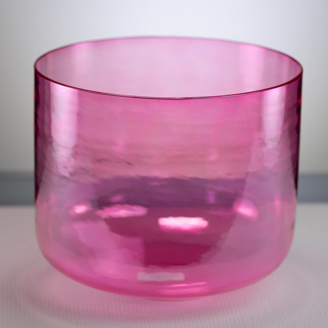 A polished pink singing bowl with a smooth, cylindrical shape, displayed against a neutral background.