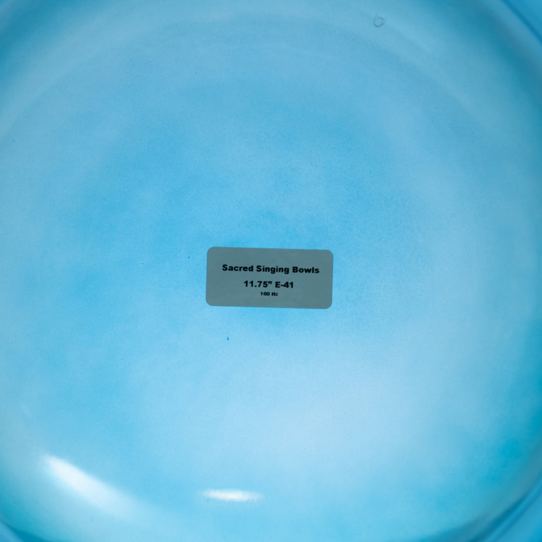 The image shows the bottom of a 11.75" E-41 Caribbean Blue Crystal Singing Bowl, with a label indicating the product name and size.