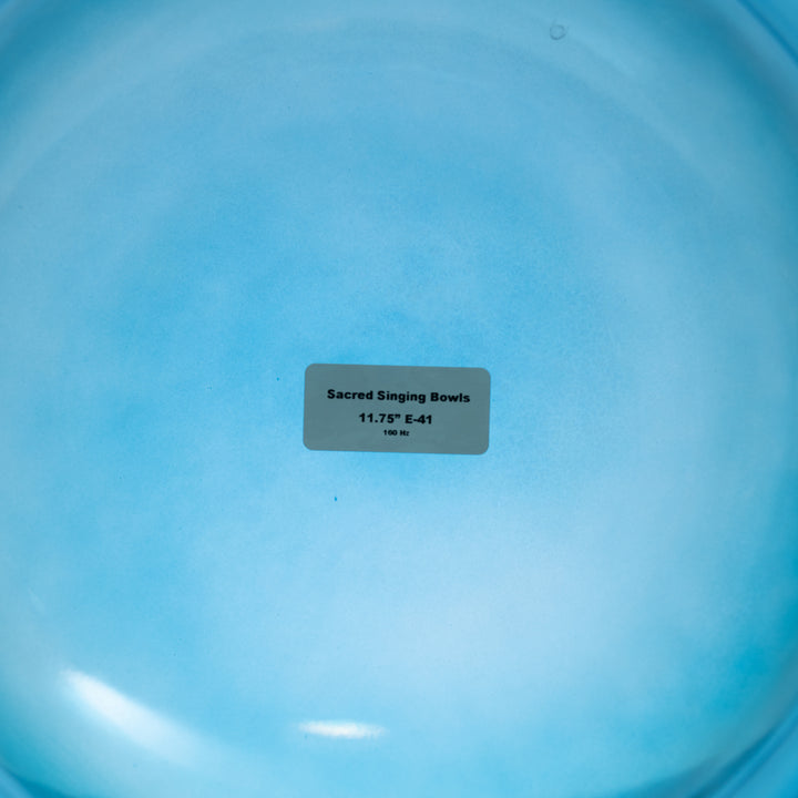 The image shows the bottom of a 11.75" E-41 Caribbean Blue Crystal Singing Bowl, with a label indicating the product name and size.