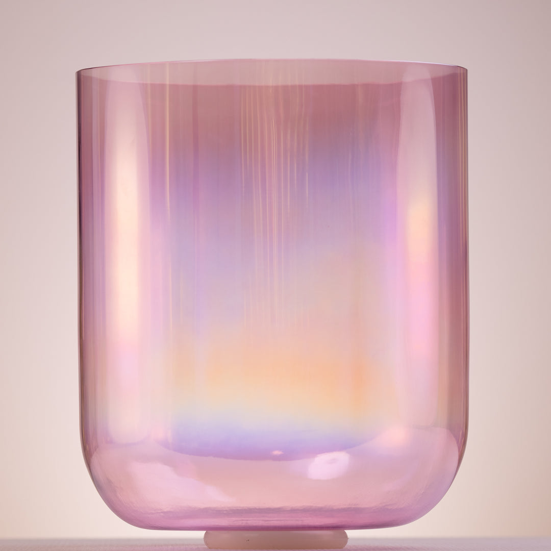 A tall, prismatic singing bowl with a light pink to purple gradient, showcasing its crystal-like qualities and a thin framed design.