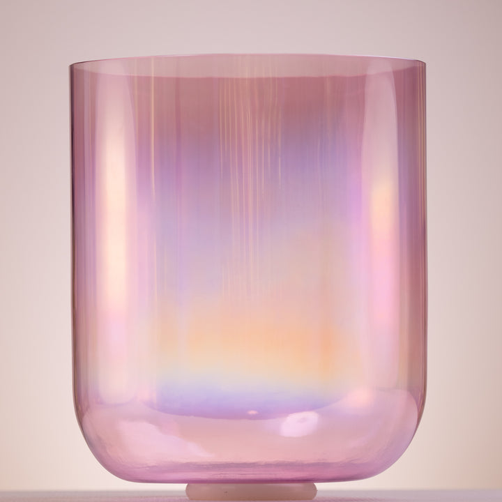 A tall, prismatic singing bowl with a light pink to purple gradient, showcasing its crystal-like qualities and a thin framed design.