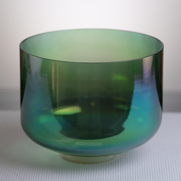 An 11-inch F#-21 Earth Magic Crystal Singing Bowl with a prismatic dark green color, placed on a white surface.