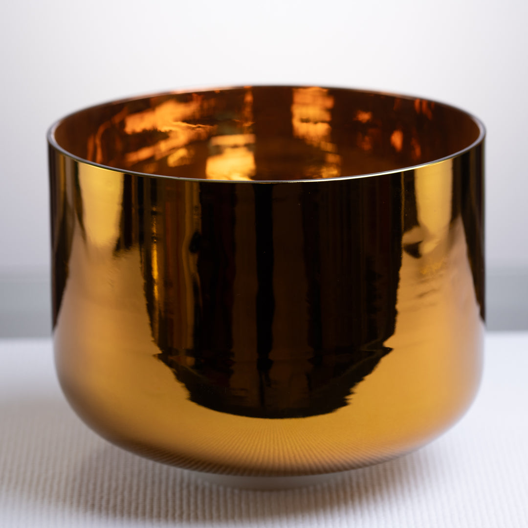 An 11-inch gold-colored crystal singing bowl with a smooth, reflective surface.