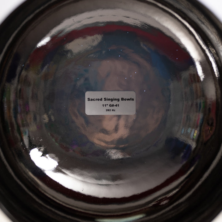 Close-up of a reflective surface with 'Sacred Singing Bowls' label