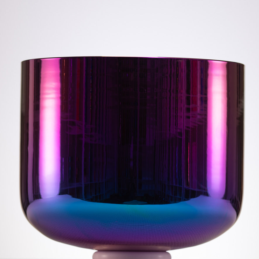 Multicolored glass bowl with purple and blue reflections on a white background
