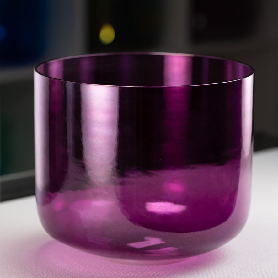 A 12-inch dark purple healing violet flame crystal singing bowl on a wooden surface, with a blurred background.