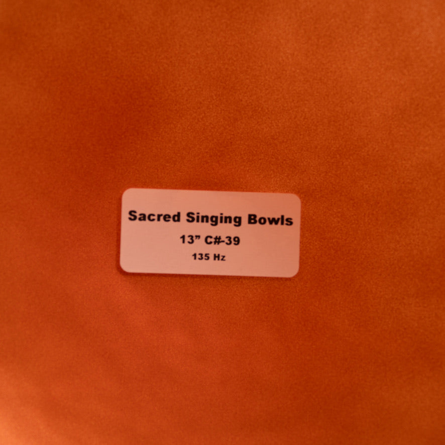 Label on a copper background indicating 'Sacred Singing Bowls' with dimensions and frequency details.
