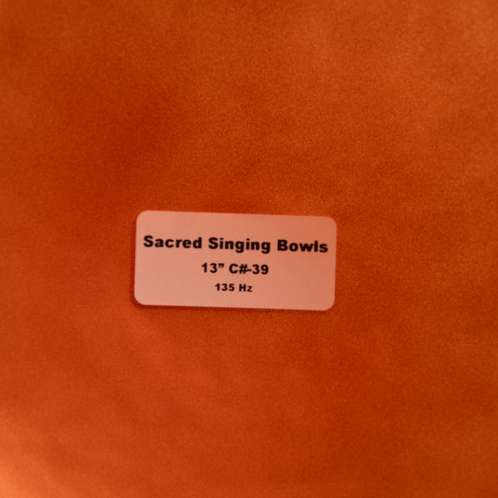 Label on a copper background indicating 'Sacred Singing Bowls' with dimensions and frequency details.