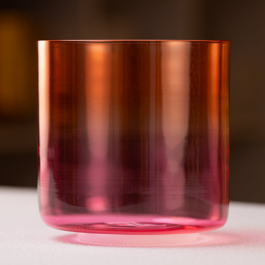 A 5.5 inch A-39 Harmonic Sunrise Crystal Singing Bowl with a gradient of orange to pink color.