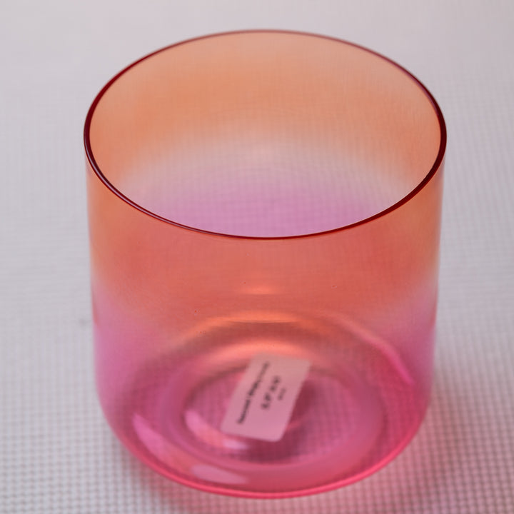 A-39 Harmonic Sunrise Singing Bowl in orange, with a smooth surface and a small white tag attached to the side.