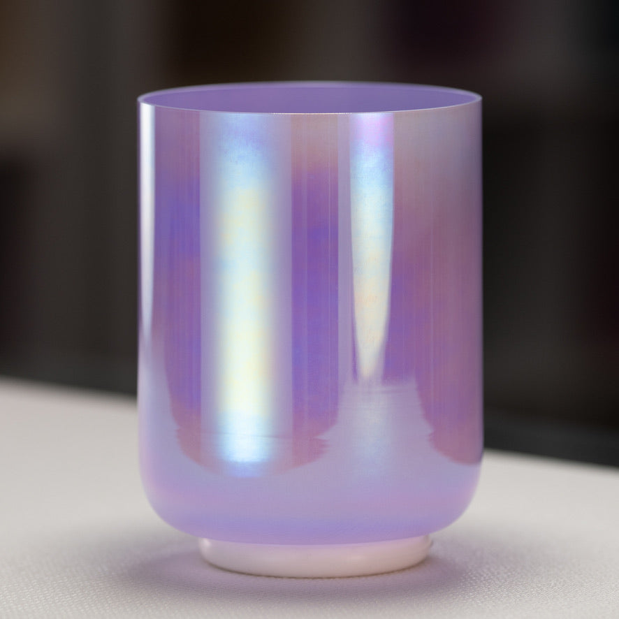 A prismatic, light purple colored crystal singing bowl with a reflective surface.