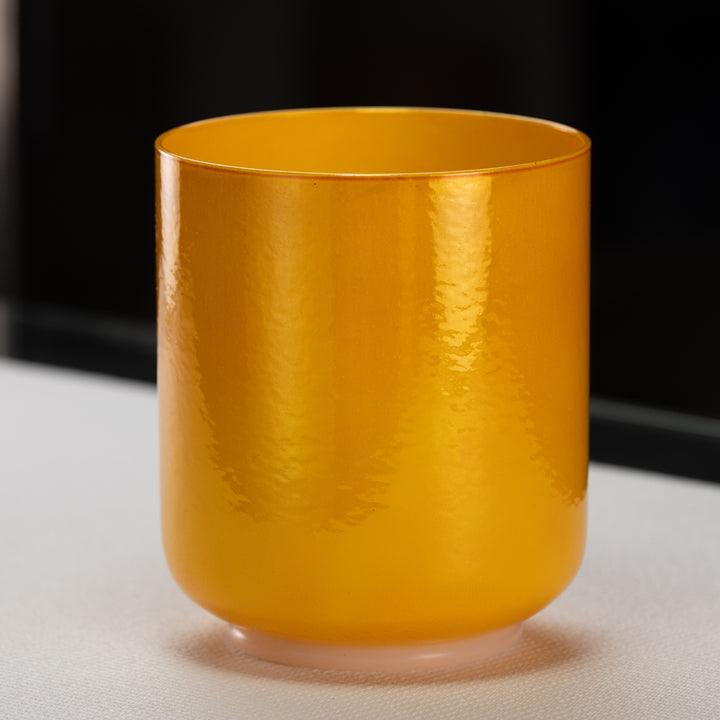 A yellow, 6.25 inch F-8 Honeycomb Singing Bowl made of quartz crystal, with a smooth, round base and a perfect pitch.