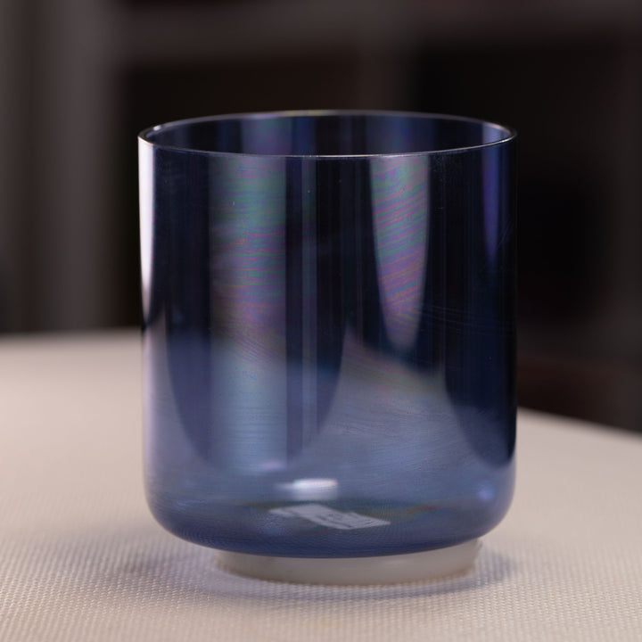 Blue singing bowl on a textured surface with a blurred background