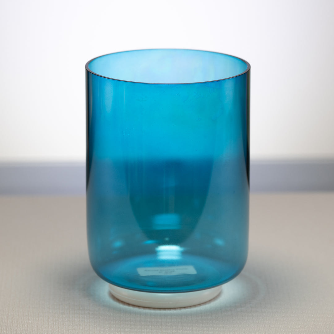 A Caribbean Blue Crystal Singing Bowl with a visible white base, the bowl has a vibrant blue color that tapers towards the base.
