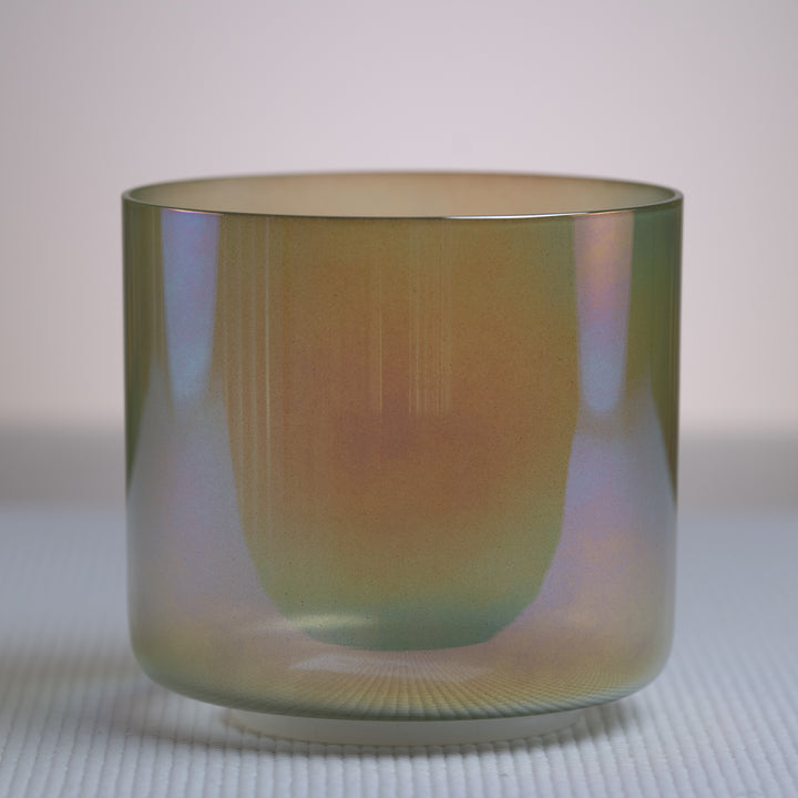 A 6-inch F#-27 Garden Goddess Crystal Singing Bowl with a prismatic effect and a metallic green color.
