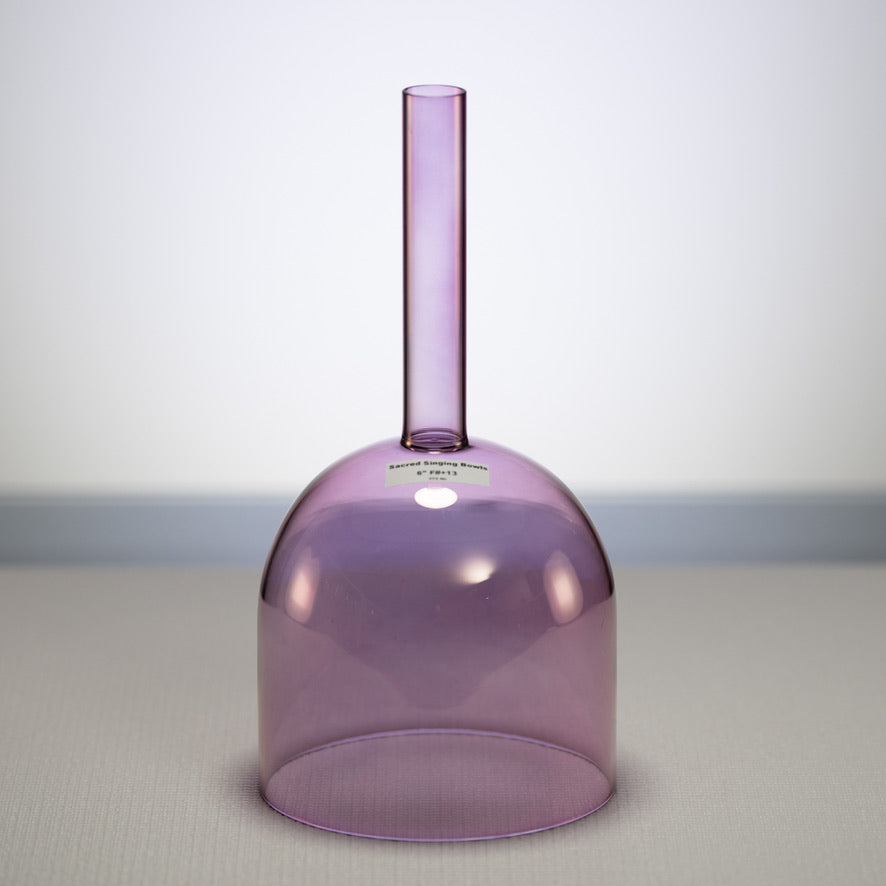 A 6-inch Solar Violet Crystal Handheld Singing Bowl with a purple hue and a handle, placed against a neutral background.