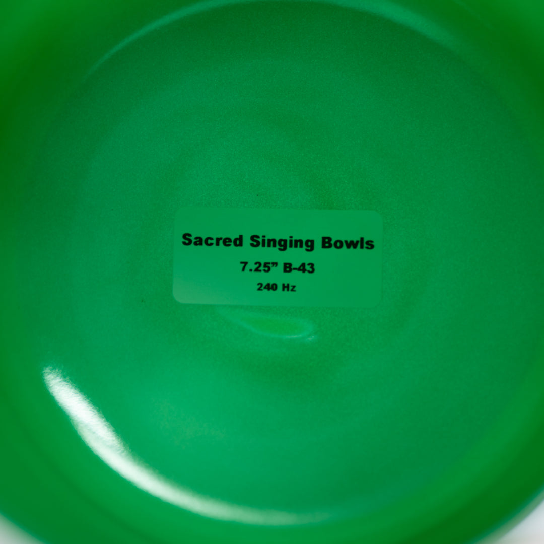 Green singing bowl with a label indicating 'Sacred Singing Bowls' and specifications.