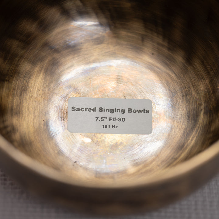 Close-up of a sacred singing bowl with a label indicating its specifications.