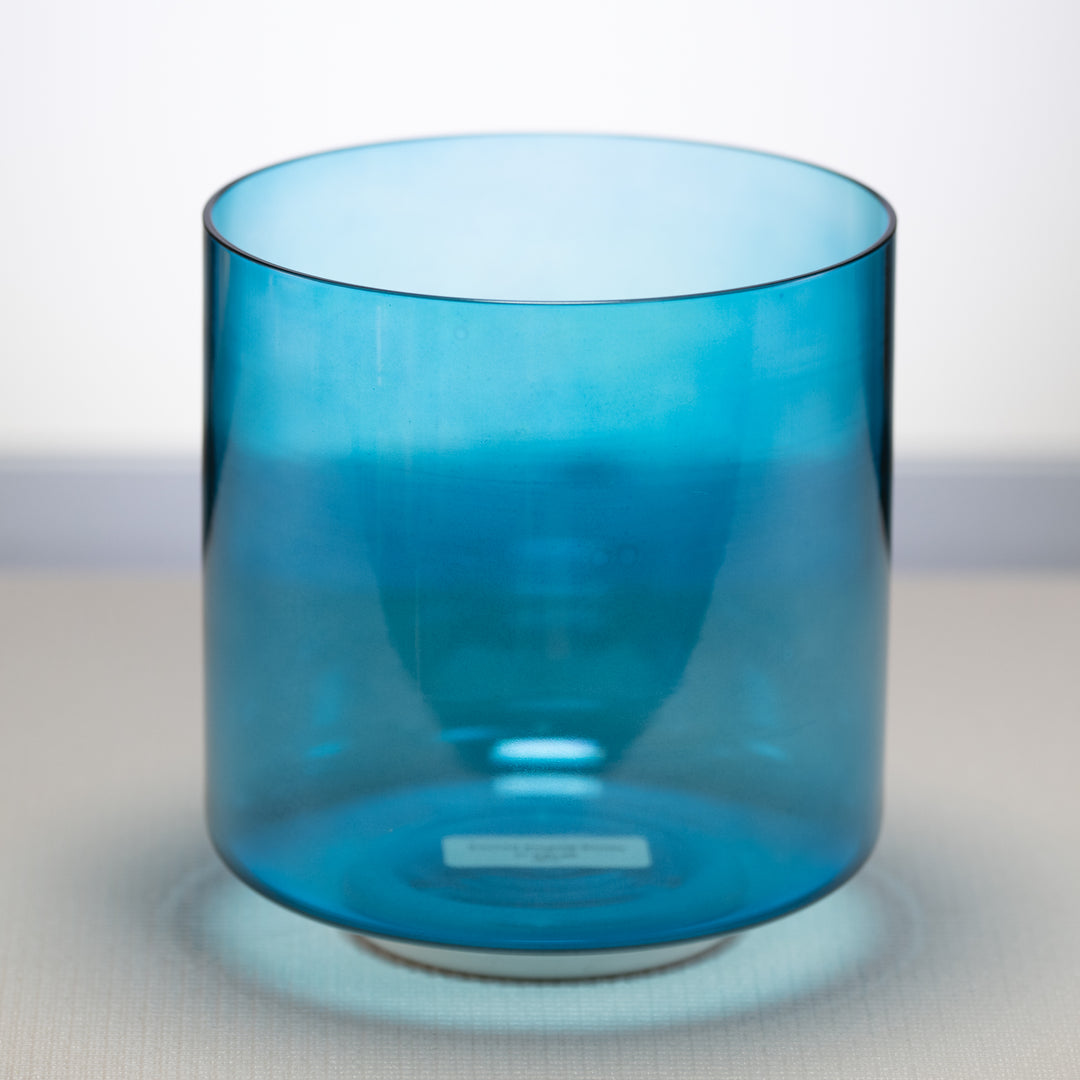 A 7-inch Caribbean Blue Crystal Singing Bowl with a binaural tone, placed on a flat surface.