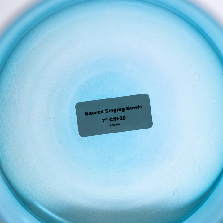 A 7 inch Caribbean Blue Crystal Singing Bowl, with a label indicating it is 'Sacred Singing Bowls', 7" C#-20, 280 Hz.