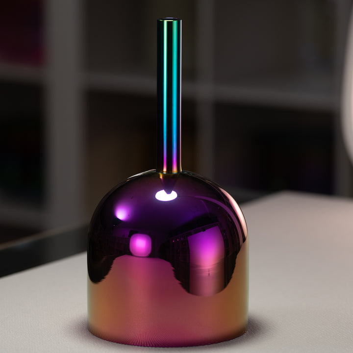 A 7 inch handheld singing bowl with a rich iridescent hue, displaying colors such as magenta, violet, pink, gold, and deep indigo, with a metallic structure.