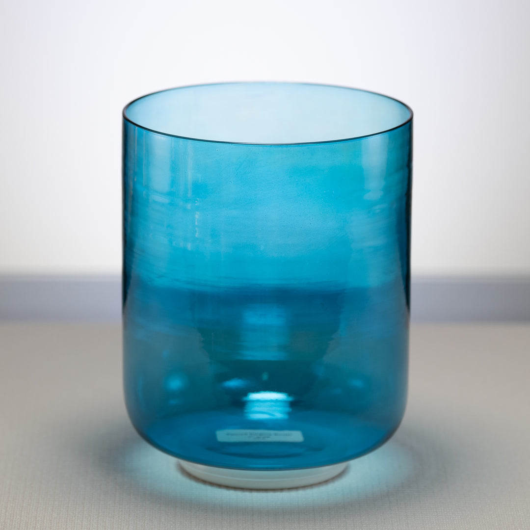 A 7-inch Caribbean Blue Crystal Singing Bowl with a visible base, placed on a flat surface.
