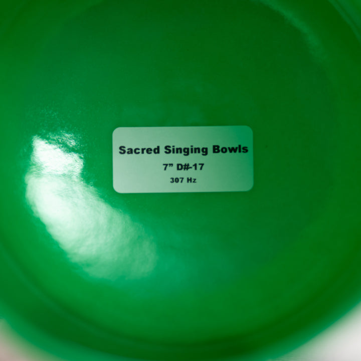 Green singing bowl with a label indicating 'Sacred Singing Bowls' and specifications.
