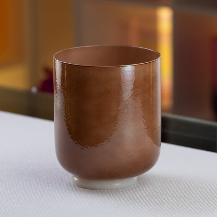 A brown crystal singing bowl with a pearlescent finish, displayed on a white surface.
