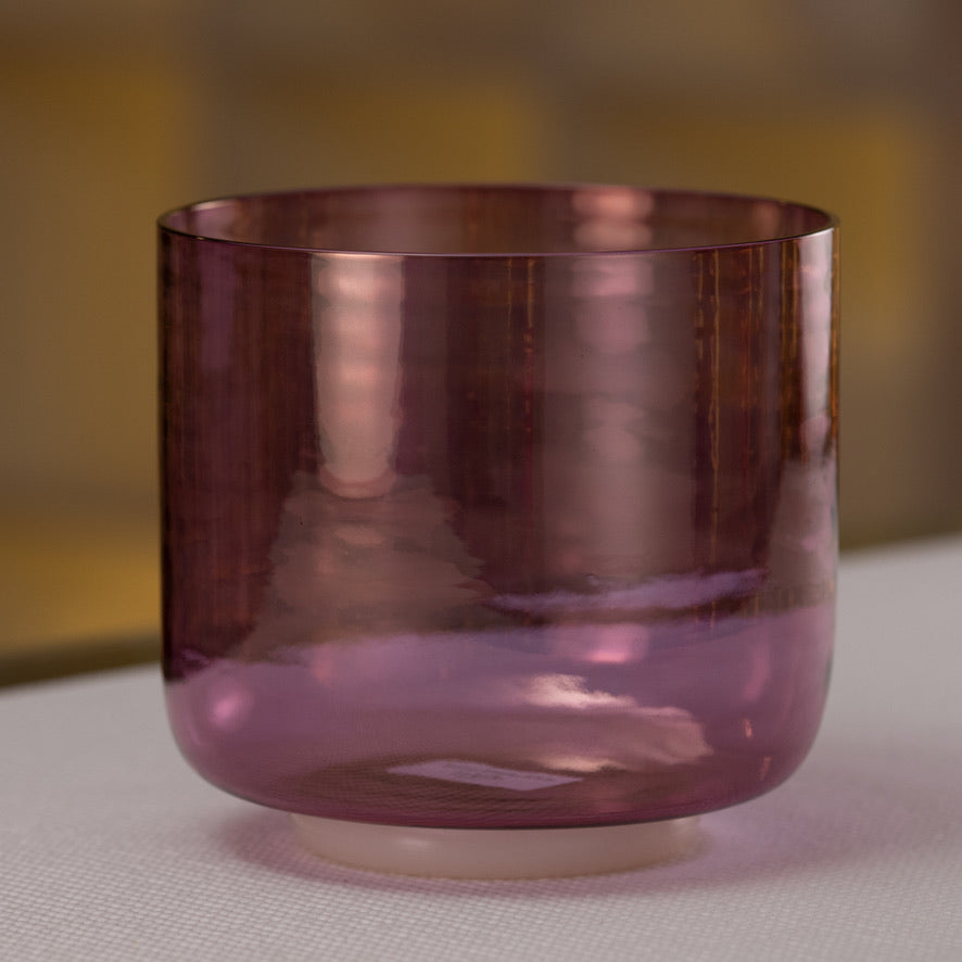 A 7-inch diameter crystal singing bowl with a violet flame color, placed on a white surface.