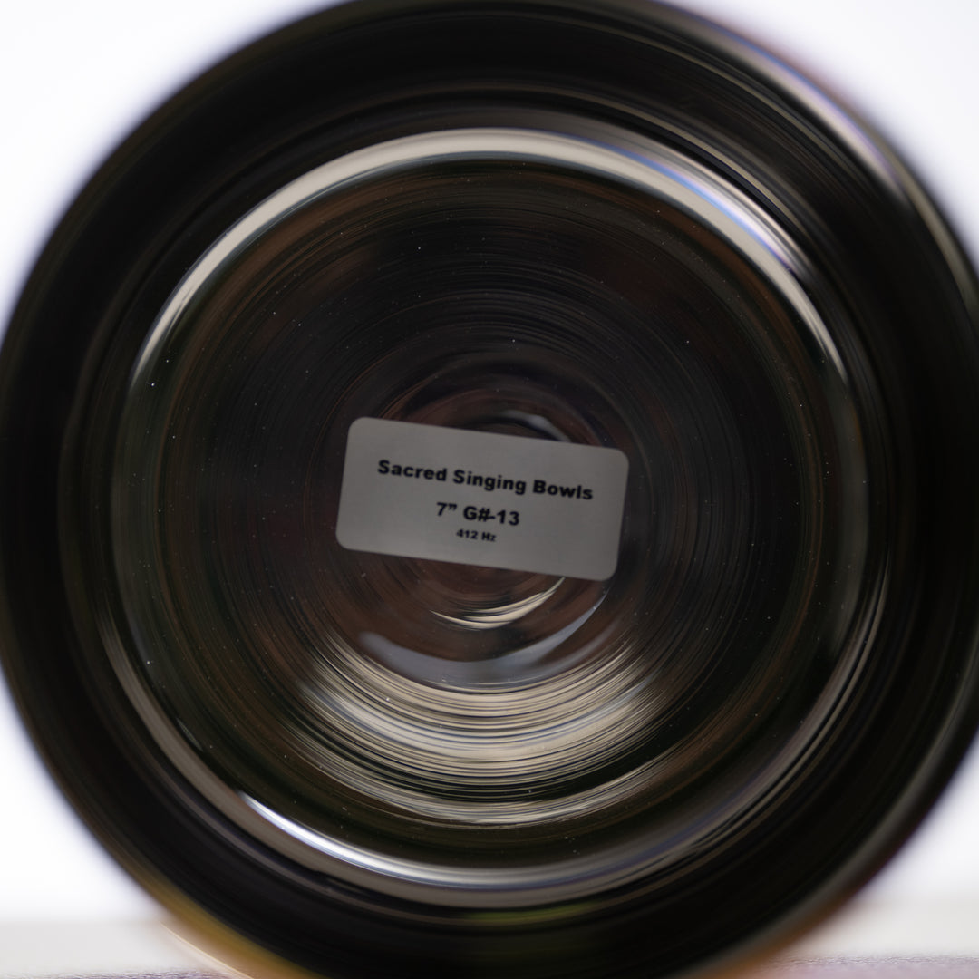 A 7 inch G#-13 Celestial Rainbow Singing Bowl with a label indicating it's from Sacred Singing Bowls, with a sticker showing the product name.