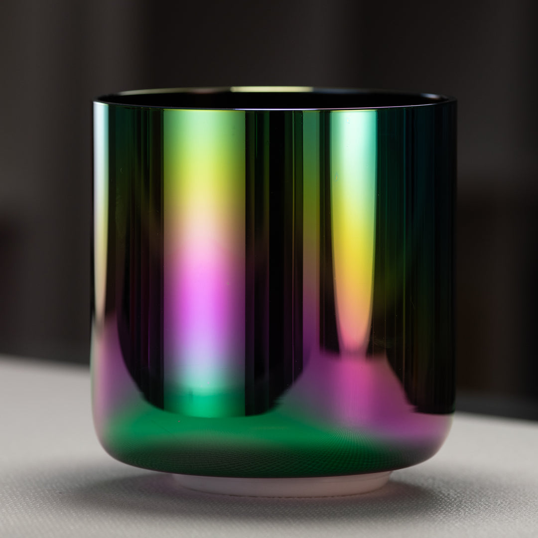 A 7-inch celestial rainbow singing bowl with a reflective surface displaying iridescent hues of magenta, violet, pink, gold, and deep indigo.
