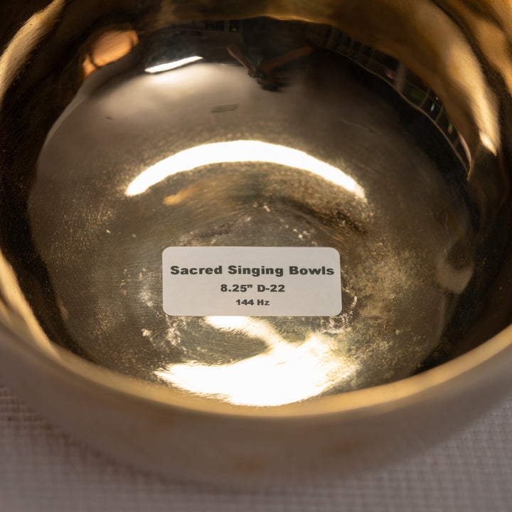 Close-up of a sacred singing bowl with a label on a white background