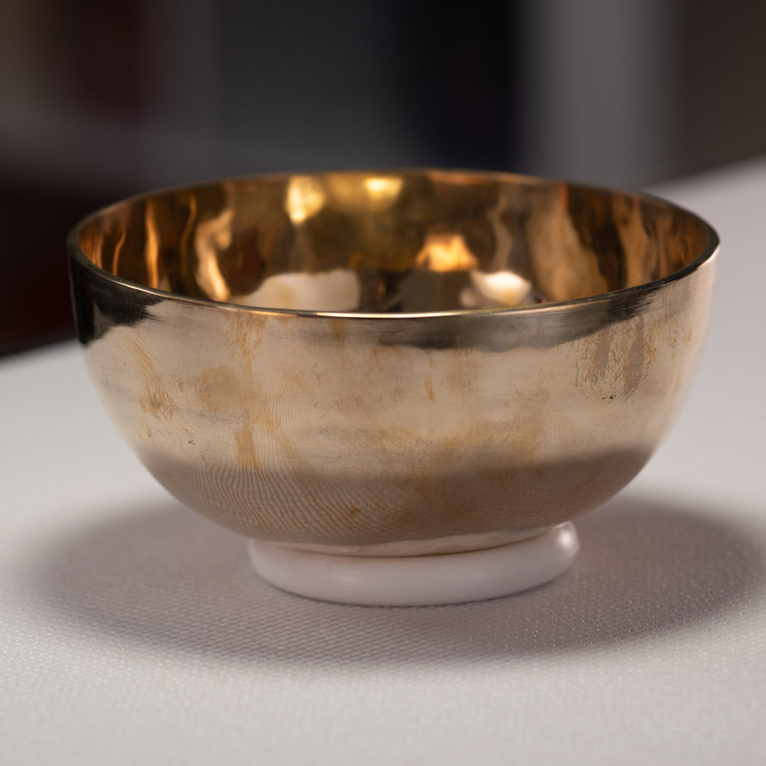Metal bowl on a white surface with a blurred background