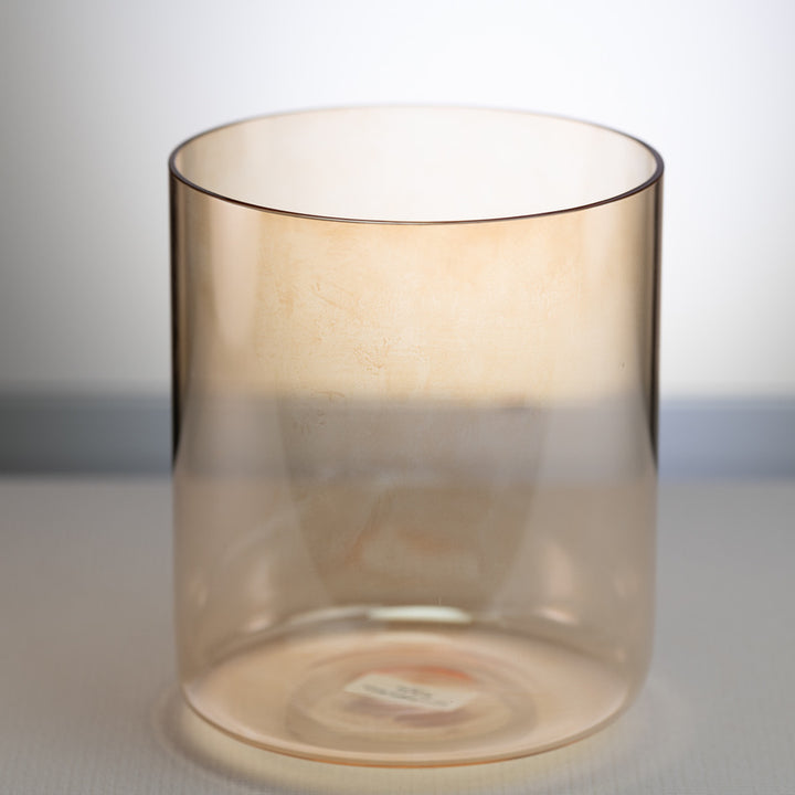 A tall, transparent singing bowl with a subtle yellow hue, made from quartz crystal.