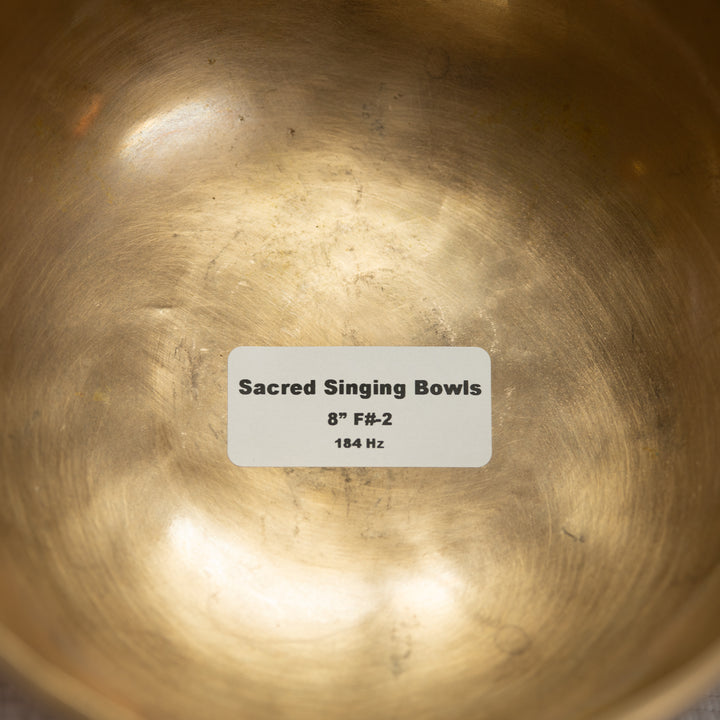 Close-up of a brass singing bowl with a label indicating size and frequency.
