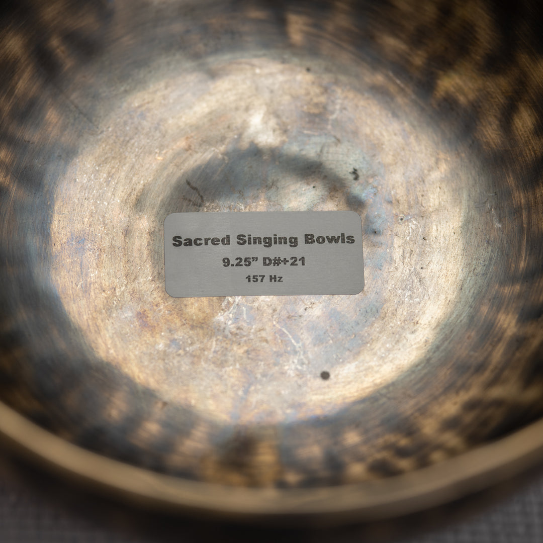 Close-up of a Sacred Singing Bowls label inside a metallic bowl
