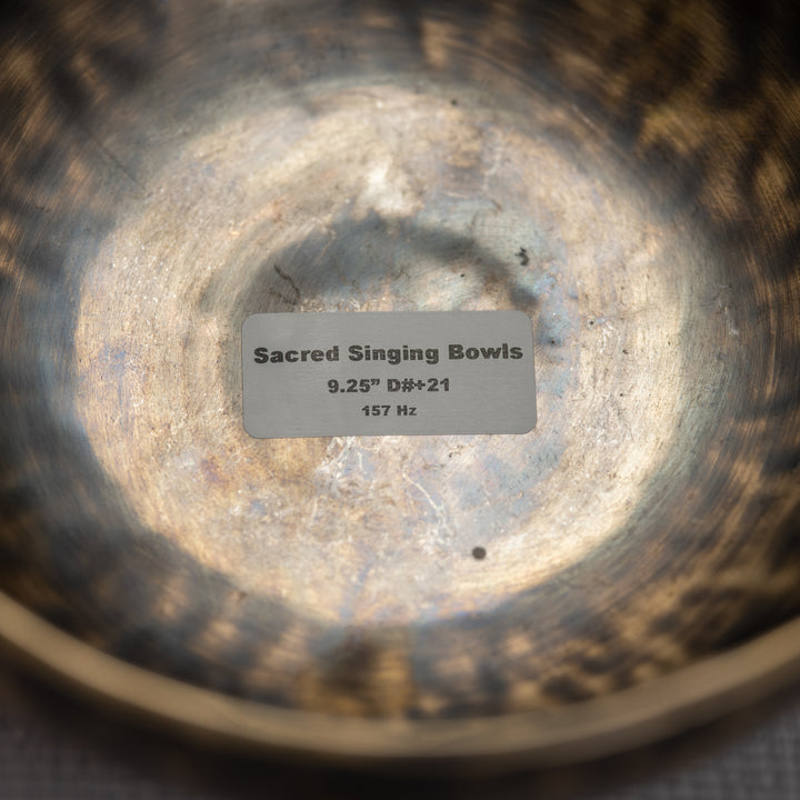 Close-up of a Sacred Singing Bowls label inside a metallic bowl