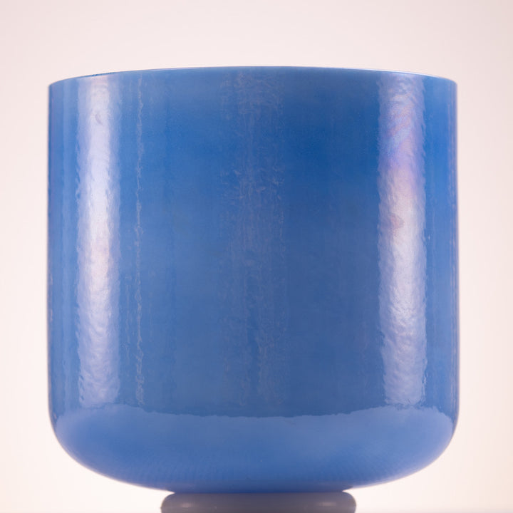 A blue crystal singing bowl with a smooth surface, displayed against a plain background.