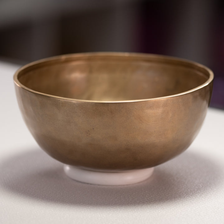 Bronze bowl on a gray surface with a blurred background
