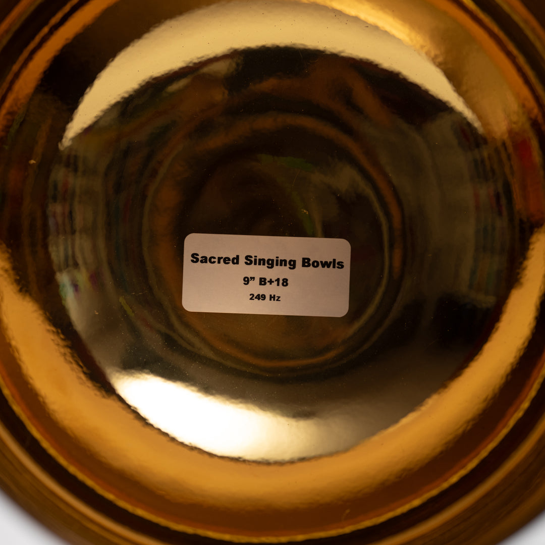 Close-up of a gold singing bowl with a label indicating its specifications.