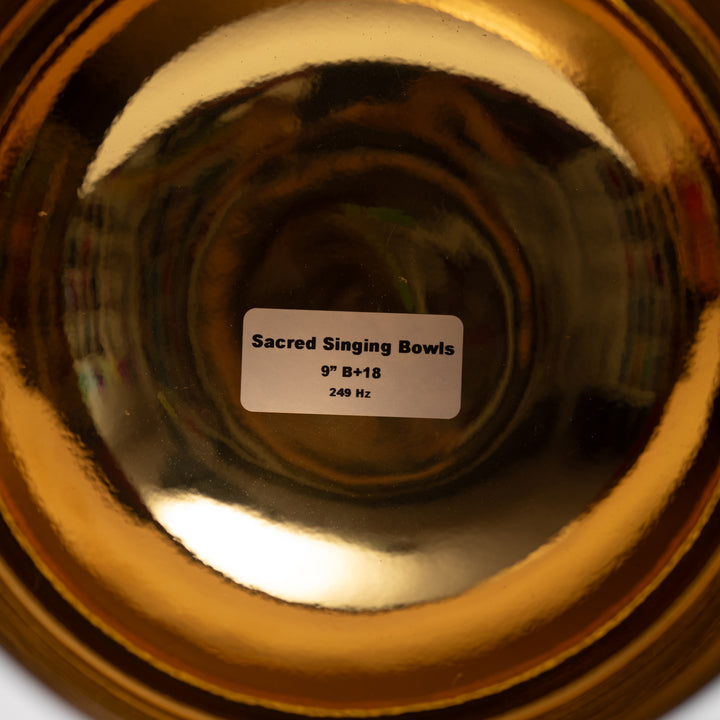 Close-up of a gold singing bowl with a label indicating its specifications.