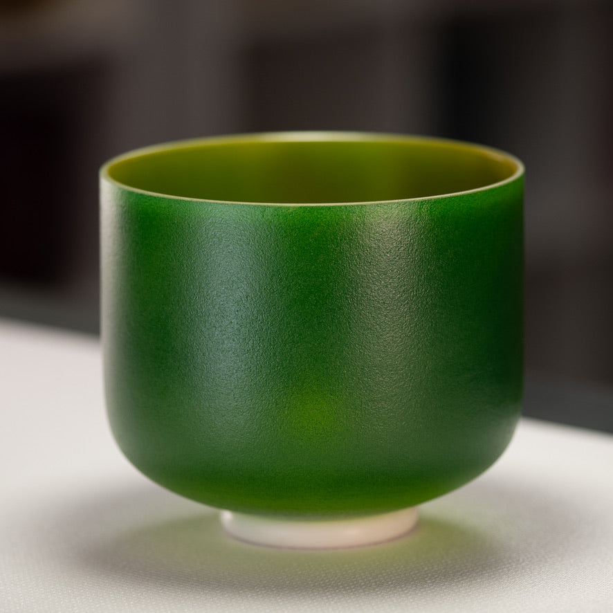 A 9-inch frosted green crystal singing bowl with a gold interior, placed on a white surface.
